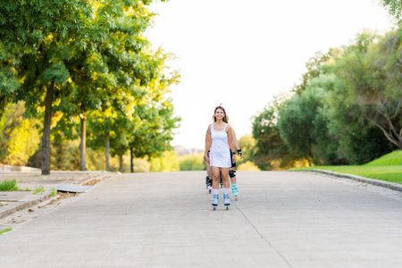 People skating in line in the middle of the street in a park