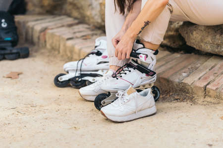 Unrecognizable woman puting on inline skates in a parkの写真素材