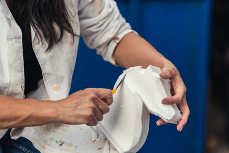 Woman making the figure of a horse with polystyrene foam outdoorsの写真素材