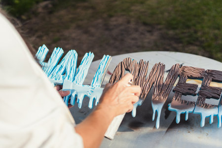 Person painting polystyrene letters with brown paint in sprayの写真素材