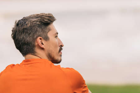 Back of a sportive man sitting on a parkの写真素材