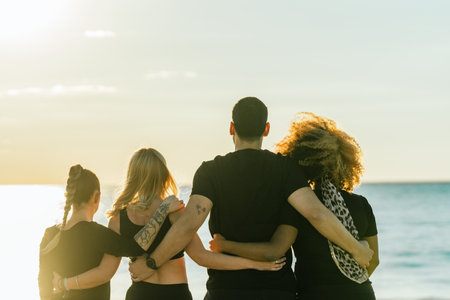 Back of a multiethnic yoga class group embracing for the back facing the seaの写真素材