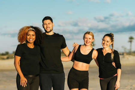 Multiethnic yoga class group standing facing the camera outdoors