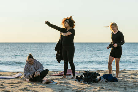 Members of a yoga class putting on clothes after a yoga class on the beachの写真素材