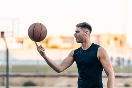 Basketball player juggling a ball on an outdoor courtの写真素材