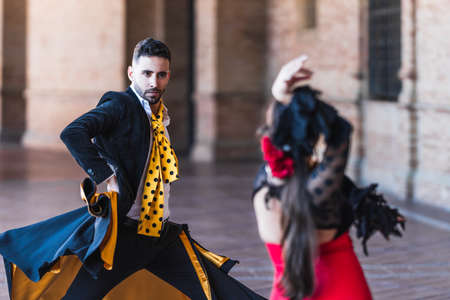 Selective focus on a man with a cape dancing flamenco with a woman outdoorsの写真素材