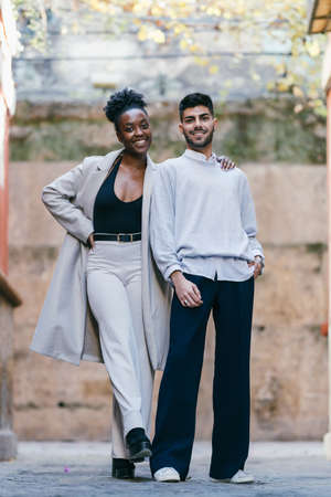 Two models of different ethnicities posing together on the street