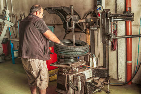 Mechanic using electrical machinery to repair and balance a car tyreの写真素材