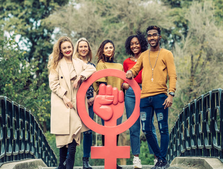 5 multiethnic people around a big cork feminist symbol smiling and looking at the camera.の写真素材