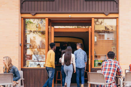 multiethnic group of friends arriving at a tavern for lunchの写真素材