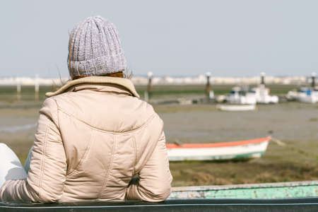 woman on her back leaning against a fishing boatの写真素材