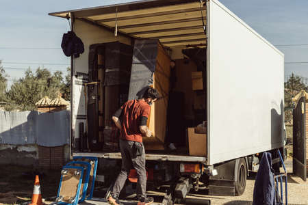 two men loading a piece of furniture onto a moving truck
