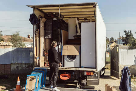 worker observes the arrangement of the packages inside a moving truckの写真素材