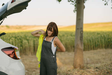 mature woman putting on reflective vest for security