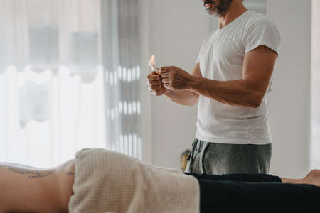 physiotherapist setting fire to absorbent cotton to warm up the suction cupsの写真素材