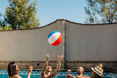 4 friends play in a swimming pool with a ball