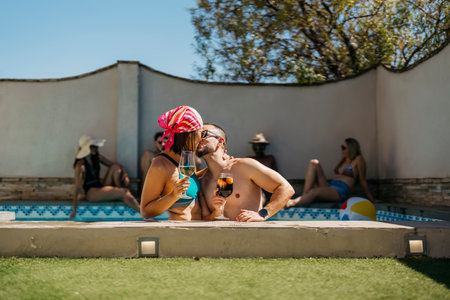 a latin engaged couple kissing inside a swimming poolの写真素材
