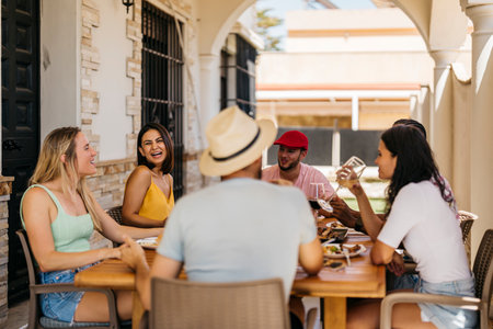 two girls laugh with friends at a barbecue celebrationの写真素材