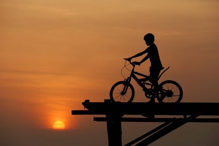 boy on bike sunsetの写真素材