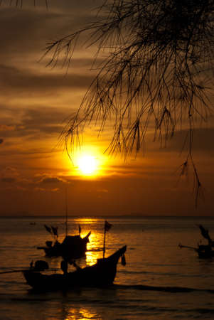 long tail motor boat in sunset at samui thailandの写真素材