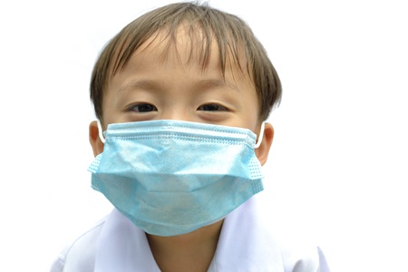 cute asian young boy wearing disposable face mask on white background.