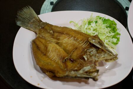 A dish of deep fried fish closed up view.