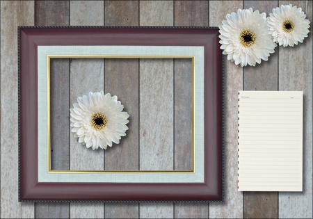 Blank photo frame with blank paper on wood background.