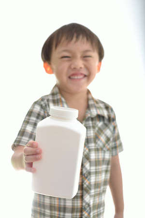 Cute asian boy with a white bottle on white background.