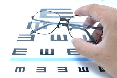 Vision idea by eye glasses frames on vision testing chart background.の写真素材
