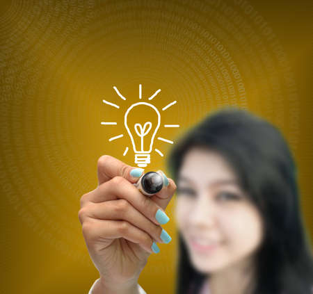 business selection concept by business woman writing business object on gradient yellow background.の写真素材