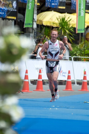 SAMUI, THAILAND - APRIL 22 2012: Samui triathlon 2012 event. Overall champion David Dellow in action during finish the triathlon on Sunday 22 April 2012 in Ko Samui island, Suratthani, Thailand.のeditorial素材