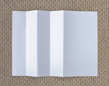 Folded empty white paper on background.
