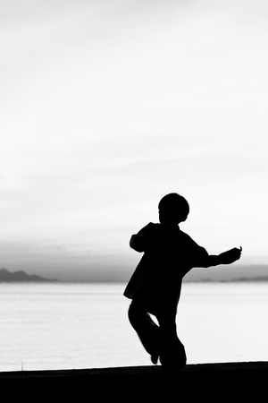 Silhouette taekwondo boy on the beach at dusk. Black and whit picture.の写真素材
