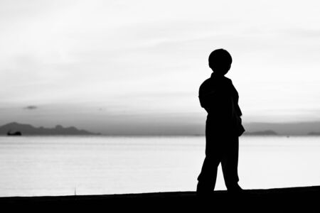 Silhouette taekwondo boy on the beach at dusk. Black and whit picture.の写真素材