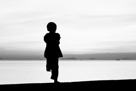 Silhouette taekwondo boy on the beach at dusk. Black and whit picture.の写真素材