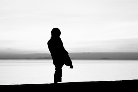 Silhouette taekwondo boy on the beach at dusk. Black and whit picture.の写真素材