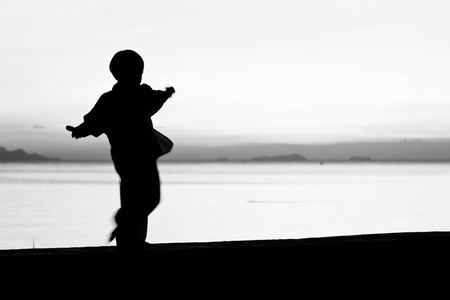 Silhouette taekwondo boy on the beach at dusk. Black and whit picture.の写真素材