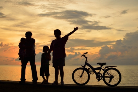 Biker family silhouette  at the beach at sunset.の写真素材
