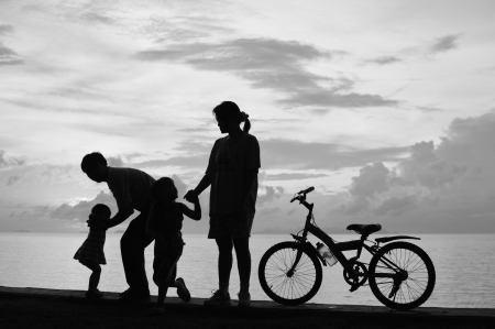 Biker family silhouette  at the beach at sunset.の写真素材