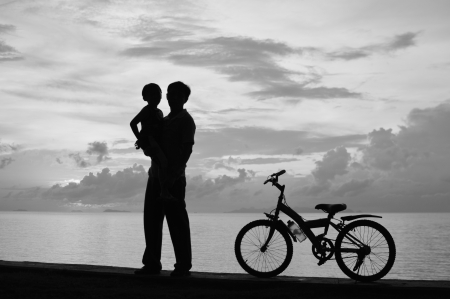 Biker family silhouette  at the beach at sunset.の写真素材
