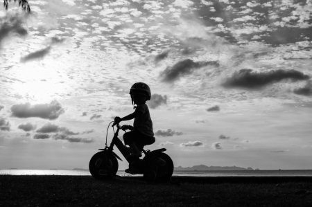 Biker family silhouette on the beach at sunset.の写真素材