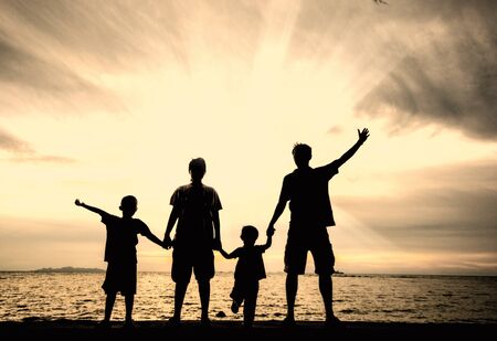 silhouette of happy family at the beach.の写真素材