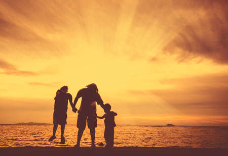 silhouette of happy family at the beach.の写真素材