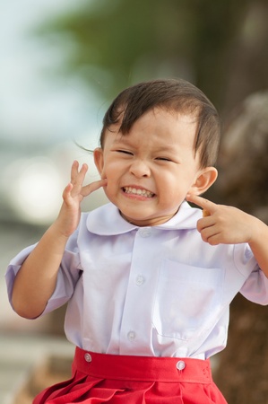 Cute asian school girl with funny pose portrait.の写真素材