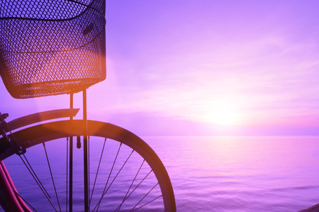 Silhouette of a bicycle on the beach at dusk.の写真素材