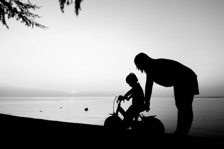 Silhouette of family on the beach at dusk.の写真素材