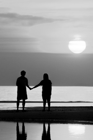 Silhouette of family on the beach during sunset.の写真素材