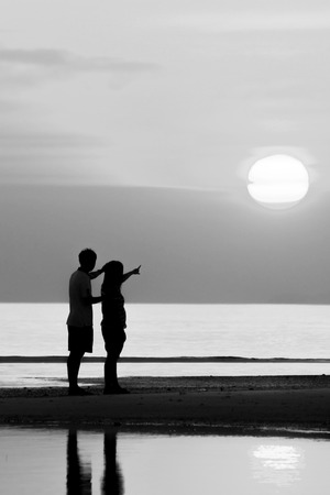 Silhouette of family on the beach during sunset.の写真素材
