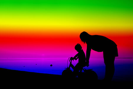 Silhouette of family on the beach at dusk.の写真素材