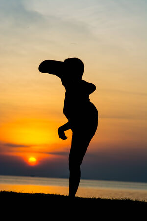 Silhouette of a boy on the beach during sunset.の写真素材